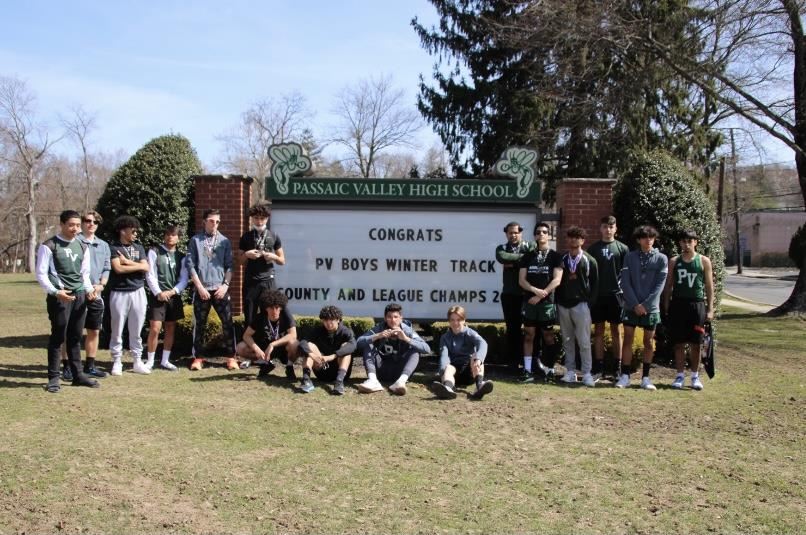 Boys Track stars in front of the sign congratulating their achievements; property of Mr. Thornton