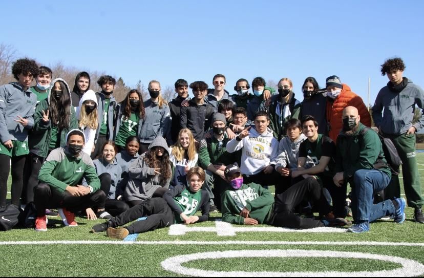 Track stars posing near mid-field of the football field; property of Mr. Thornton